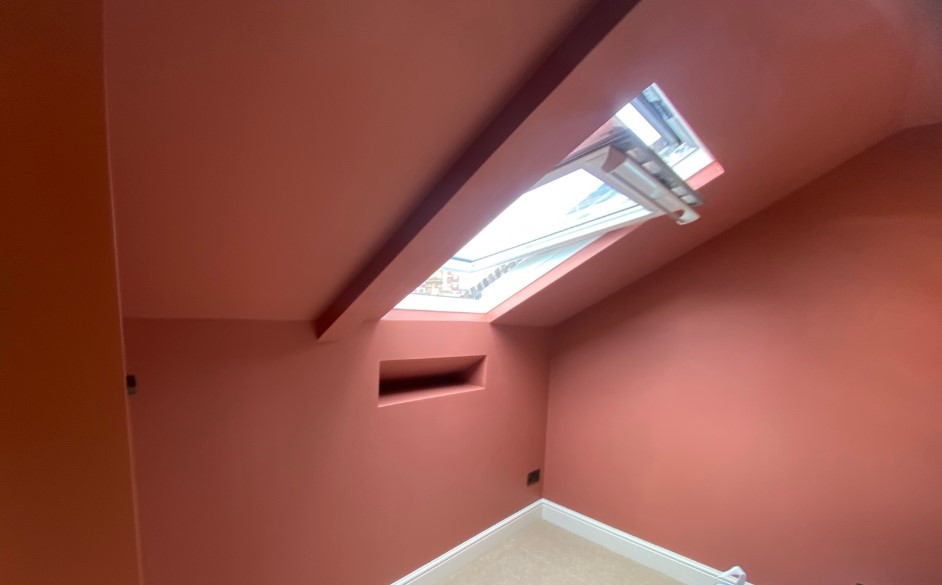Terracotta painted ceiling and wall around a roof window